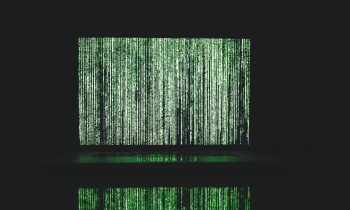 Abstract depiction of green matrix code on a computer monitor.